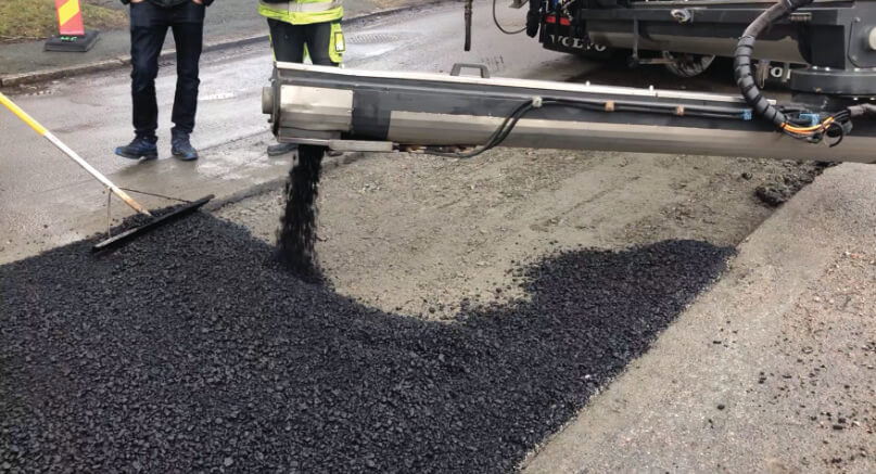 Asphaltverteiler während der Verteilung auf kleiner Asphaltfläche