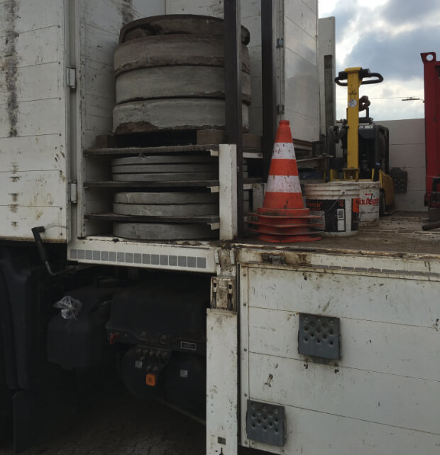 Fächer mit alten Kanaldeckel auf dem Lkw